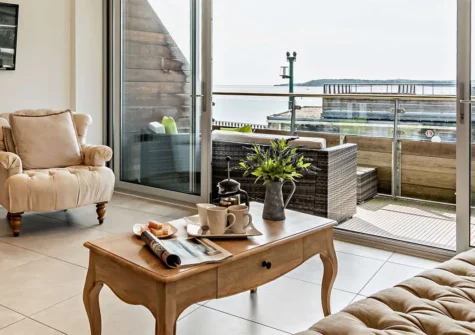 11 Waters Edge, Tenby is a deluxe 2-bedroom first-floor retreat with contemporary furnishings, stunning views of Tenby South Beach, and easy access to local attractions, ideal for couples or families seeking indulgence during their seaside getaway.