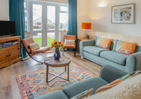 3 Bro Terfyn, Morfa Nefyn is a charming three-bedroom bungalow just half a mile from the beach, boasting pretty front and rear gardens, a cosy pastel-hued lounge, and effortless access to the Llyn Peninsula's dramatic coast path and sandy shores.