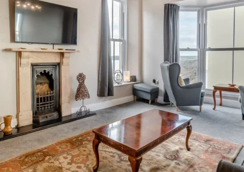 Beaufort Apartment, Tenby is a spacious three-bedroom retreat just 50 metres from South Beach, featuring panoramic sea views from bay windows, a cosy woodburner, contemporary coastal interiors, and the medieval town centre on your doorstep.