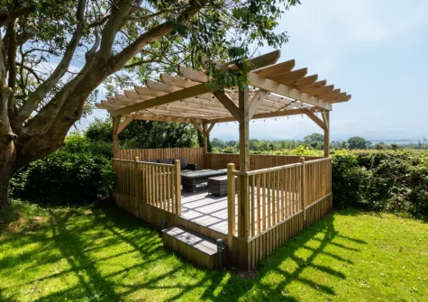 The enclosed lawned garden, decked patio & outdoor sitting area at Blochdy, Brynsiencyn