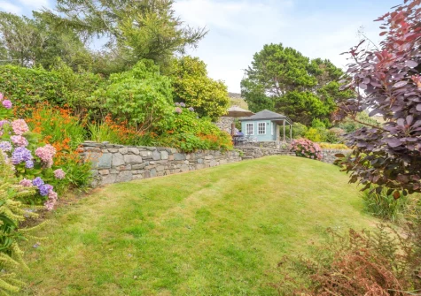 The beautifully manicured lawned garden & summer house at Bron Y Gadair, Llanfair