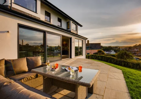 The patio, alfresco dining area & garden, offer uninterrupted views of the sea, at Bryn Benar, Abersoch