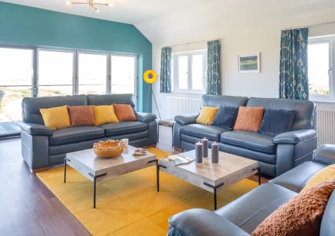 Bryn Deufor, Anelog is a spacious five-bedroom house near Aberdaron on the Llyn Peninsula, boasting a private hot tub, glass-fronted balcony, games room and sweeping coast and countryside views, perfect for unforgettable family gatherings.