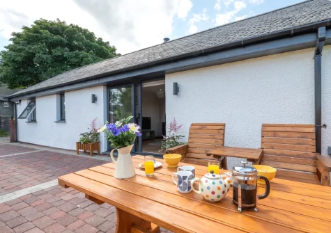 The enclosed patio & alfresco dining area at Bryniau Pair Ucha Cottage, Pandy Tudur