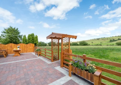 The enclosed patio & alfresco dining area, with access to the field to execise your dogs, at Bryniau Pair Ucha Cottage, Pandy Tudur