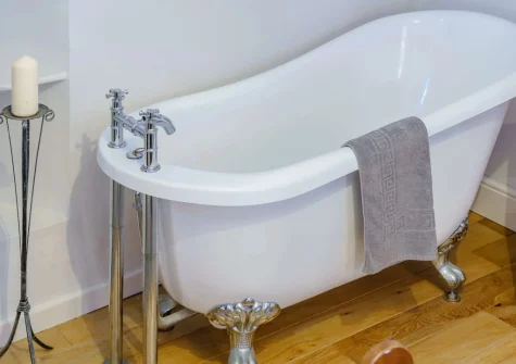 Bedroom #1, with a roll-top bath, at China Cottage, Tenby