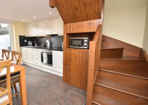 The kitchen with stairs up to the living area & bedrooms at Delfryd Cottage, Saundersfoot