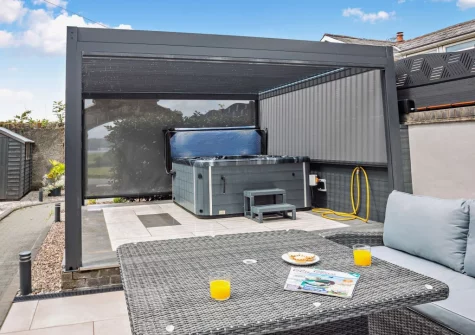The enclosed courtyard garden, alfresco dining area & hot tub at Dwyryd Estuary View, Talsarnau