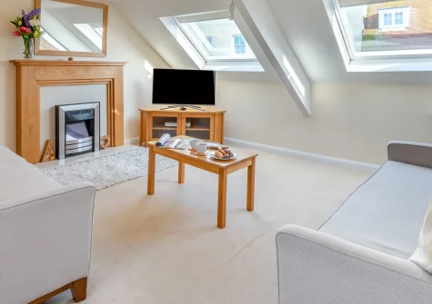 Fisherman's Loft, Tenby is a contemporary third-floor apartment just 200 metres from North Beach, featuring stunning harbour views through skylights, coastal-inspired interiors, and effortless access to Pembrokeshire's beaches and historic streets.