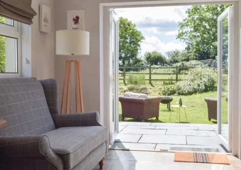 The kitchen, with doors leading out into the garden, at Hafan Fach Cottage, Maidenwells