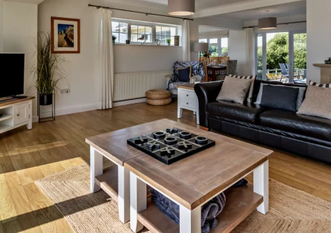 Hillside, Abersoch is a spacious four-bedroom retreat on an elevated plot in the heart of this coastal village, featuring wrap-around gardens with countryside and ocean views, contemporary interiors, and easy access to golden beaches.