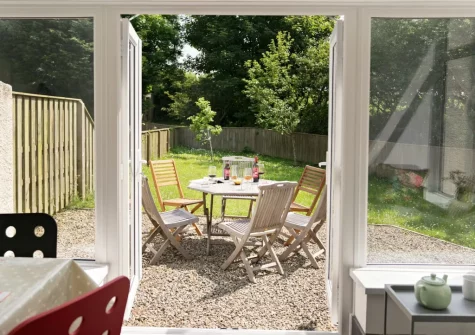 Step out onto gravel patio, alfresco dining area & garden at Holly Cottage at Woodlands Farm, Little Haven