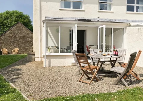 The gravel patio, alfresco dining area & garden at Holly Cottage at Woodlands Farm, Little Haven