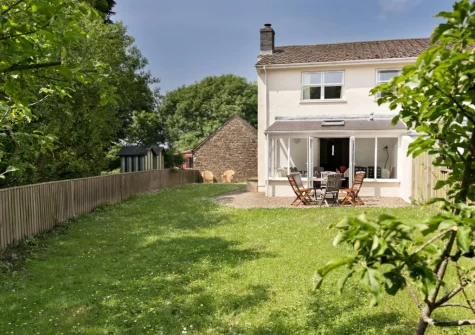 The gravel patio, alfresco dining area & garden at Holly Cottage at Woodlands Farm, Little Haven