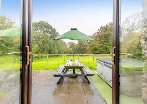 The patio, alfresco dining area, hot tub & gaden at Hunter's Hollow, St Florence