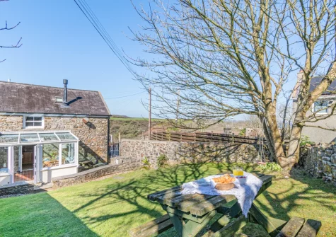 The alfresco dining area & lawned garden at Ivy Cottage, Little Haven