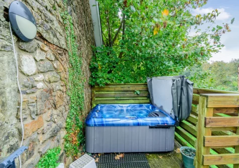 The terrace & hot tub at Keepers Cottage at East Tarr Farm, St Florence