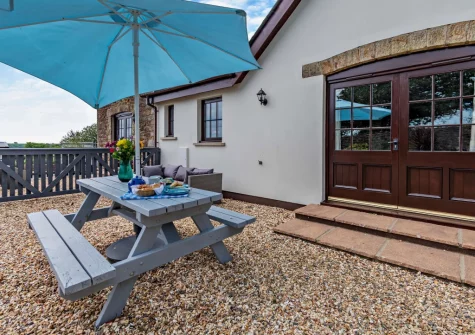 The gravel patio, barbecue & alfresco dining area at Loveston Lodge, Loveston