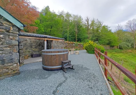 The private wood-fired hot tub & alfresco dining area at Minffordd, Penmaenpool