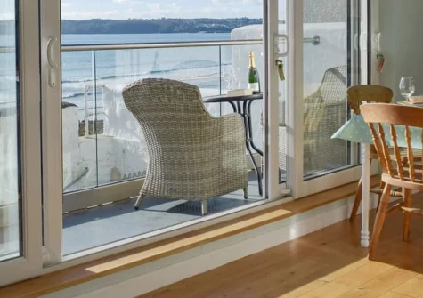 Mole End, Amroth is a distinctive two-bedroom cottage perched directly on Amroth Beach, boasting panoramic views across Carmarthen Bay to the Gower Peninsula, a private balcony for sunset watching, and the Pembrokeshire Coast Path on your doorstep.