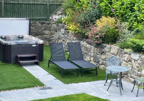 The hot tub, outdoor sitting area & enclosed garden at Nyth Y Wennol, Maenan