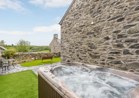 The hot tub & enclosed garden at Nyth Y Wennol, Maenan