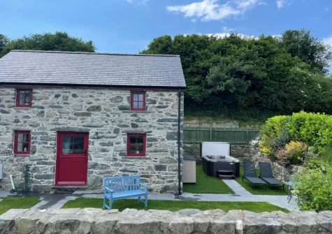The hot tub, outdoor sitting area & enclosed garden at Nyth Y Wennol, Maenan