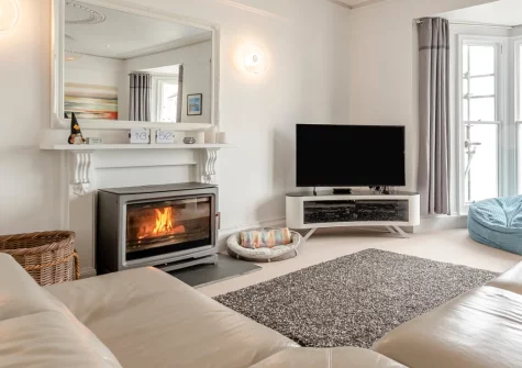 One Charlton House, Tenby is a beautifully appointed two-bedroom apartment commanding spectacular views across North Beach and the iconic harbour, featuring elegant open-plan living with wood burner, enclosed sun terrace, and prime location.