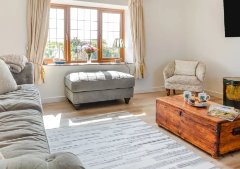 Pen Goppa, Bryncroes is a beautifully renovated three-bedroom Welsh longhouse on the Llyn Peninsula, with a private hot tub, garden bar and games room, plus sea views from the kitchen and easy access to golden beaches and coastal villages.