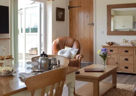 Piglets Cottage, Canaston Bridge is a peaceful single-storey retreat in rural Pembrokeshire, offering two en-suite bedrooms, bright open-plan living with patio doors opening onto a terrace, and easy access to family attractions and coastal treasures.