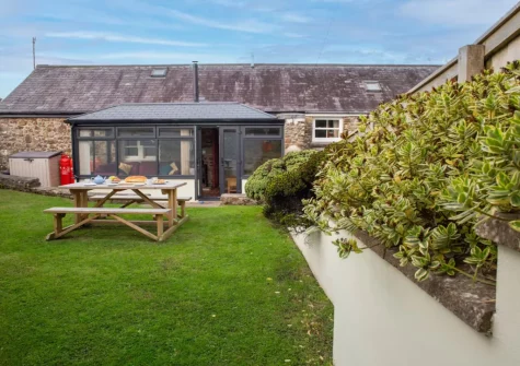 The alfresco dining area & enclosed lawned garden at Pine Cottage at Woodlands Farm, Little Haven