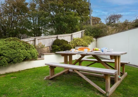 The alfresco dining area & enclosed lawned garden at Pine Cottage at Woodlands Farm, Little Haven