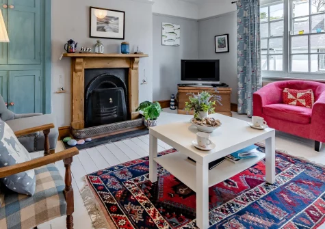 Sea Thrift, Aberdovey is a charming Welsh cottage nestled into the hillside below Snowdonia, featuring a spectacular three-tiered terraced garden with stunning estuary views, quirky retro interiors, and a winding path leading down to sandy beaches.