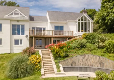 Steps lead down from the patio & alfresco dining area to the garden at Seren y Mor, Freshwater East