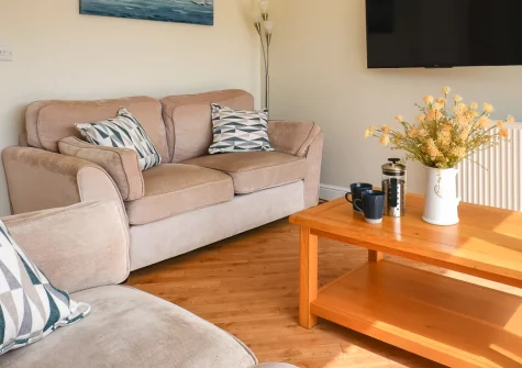 Tafliad Carreg, Abersoch is a contemporary bungalow set across from Abersoch's inner harbour, featuring a sun-trap patio with loungers, bright open-plan living spaces, and two en-suite bedrooms, with beaches and village amenities moments away.