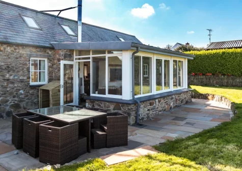 The patio, alfresco dining area & enclosed lawned garden at Temple Barn, Square and Compass