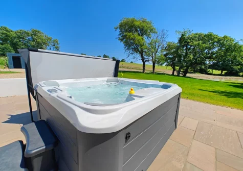 The patio, hot tub & large lawned garden at The Barn at Arnold's Hill Farm, Slebech