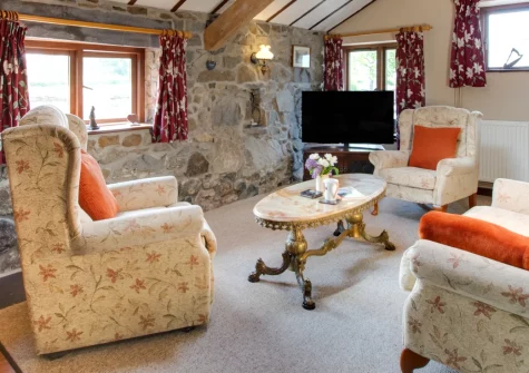The Granary, Llanfaglan is a characterful barn conversion on a working farm with stunning Caernarfon Bay views, traditional Welsh interiors featuring slate floors and exposed stone walls, and direct access to coastal walks and Snowdonia.