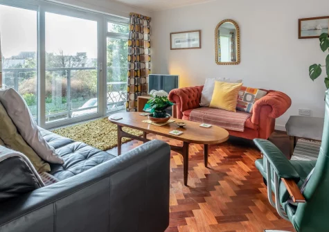 Tidey, Tenby is a charming first-floor apartment positioned just metres from North Beach, featuring a sunny private balcony with sea breezes, contemporary coastal interiors, and effortless access to Tenby's medieval harbour and independent shops.