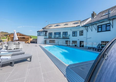 The all-weather outdoor heated swimming pool, alfresco dining & outdoor sitting area at Trebrowen, Angle