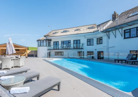 The all-weather outdoor heated swimming pool, alfresco dining & outdoor sitting area at Trebrowen, Angle