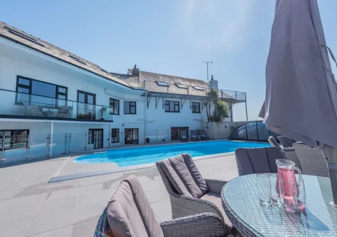 The all-weather outdoor heated swimming pool, alfresco dining & outdoor sitting area at Trebrowen, Angle