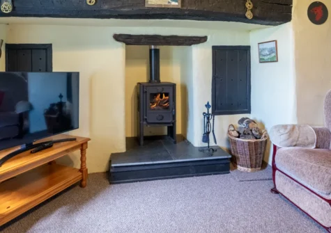 Ty Eiddew, Llanfaglan is a charming three-bedroom Welsh farmhouse near Caernarfon, boasting sea and mountain views, a cosy wood burner, enclosed garden, and easy access to Snowdonia and the beaches of the Lleyn Peninsula, ideal for family getaways.