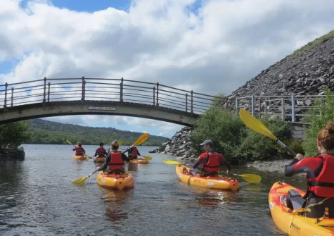 Venture to Llyn Padarn, a stunning glacially formed lake, perfect for water sports, with paddleboard, kayak rental & lessons