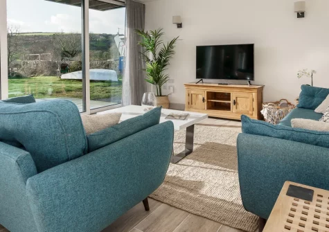 Ty Nant, Llaniestyn is a stunning contemporary semi-detached retreat on the Llŷn Peninsula, featuring designer open-plan interiors, a generous balcony with countryside views, and south-facing garden opening from floor-to-ceiling glass doors.