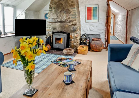 Ty'n Y Mur Cottage, Abersoch is a beautifully restored stone retreat enjoying spectacular panoramic views to Bardsey Island, featuring a cosy wood burner, glass balcony, and a very large enclosed garden, just a mile from Abersoch's golden beaches.