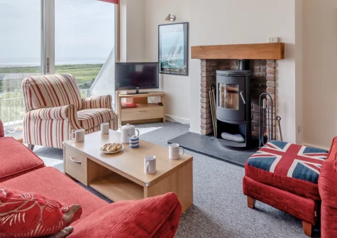 Vista Sol, Aberdovey is a delightful three-bedroom house capturing spectacular coastal estuary views from sunrise to sunset, featuring terraced gardens, cosy interiors with wood burner, and easy strolls to Aberdovey's golden beach and harbour.