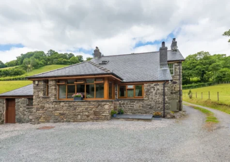 Y Felin is a characterful stone cottage with traditional features include beamed ceilings, stone walls and an inglenook with a wood burner